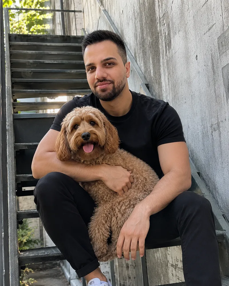 Schursan Mahmo sitzt auf einer Treppe und hält einen Hund im Arm